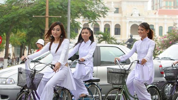 More common than lycra ... Vietnamese students wearing Ao Dai, a traditional dress, on bikes.