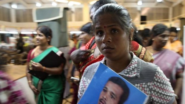 A Tamil woman holds a photo of her husband who disappeared during the final stage of the Sri Lankan civil war.
