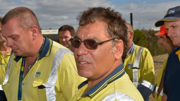 BlueScope Steel workers Shane Burd (left) and Billy Hassan (centre) speak after they were greeted with job cuts after the Christmas break.