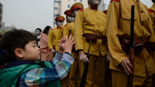 A boy in South Korea takes photos of activists dressed as colonial-era Japanese soldiers prior to their re-enactment of a crackdown in which hundreds of protesters were killed in 1919 during demonstrations calling for independence from Japan.
