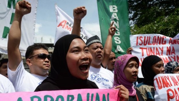Filipino Muslims shout slogans in support of the passage of a law giving autonomy to minority Muslims.