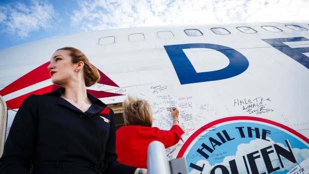 Crew members who staffed Delta Air Lines' final Boeing 747 flight autograph the plane at Pinal Airpark in Marana, Arizona, earlier this month.