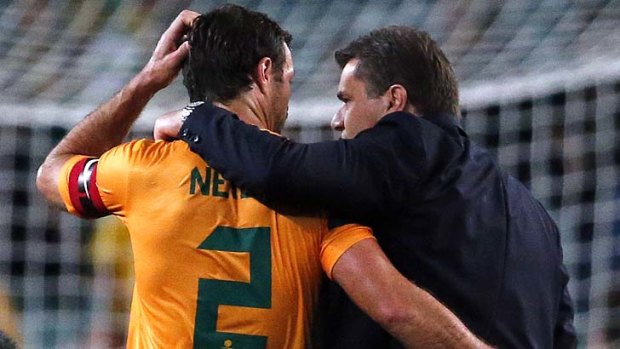 Socceroos coach Ange Postecoglou (right) hugs captain Lucas Neill.