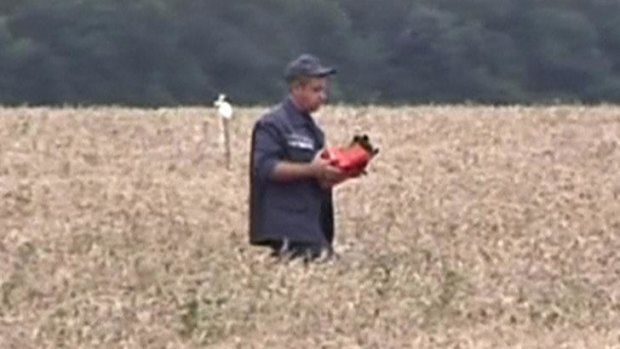 A rescue worker carries what is believed to be a flight data recorder at the crash site of Malaysia Airlines flight MH17 near Hrabove.