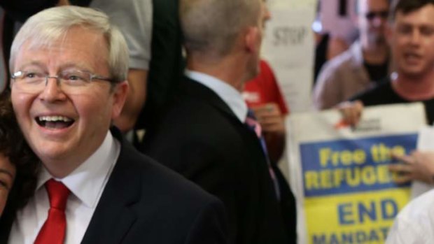 Prime Minister Kevin Rudd unfazed by protesters as he casts his vote in Brisbane on Saturday 7 September 2013.