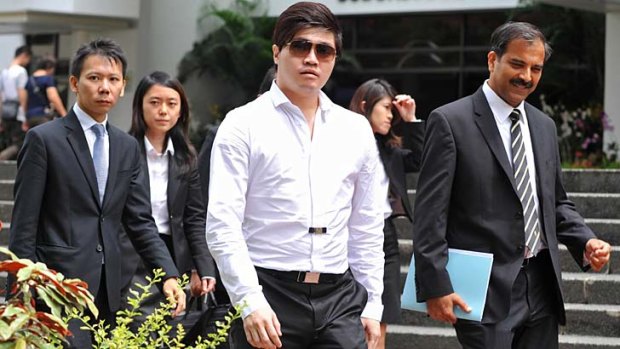 Singaporean businessman Eric Ding Si Yang (centre) leaves a district court with his lawyers during a break on the first day of his corruption trial in Singapore on Monday.