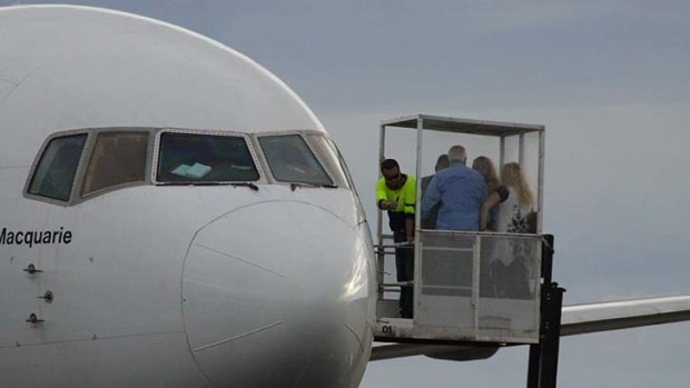 A forklift is used to remove passengers from a plane forced to make an emergency landing in Mount Isa.