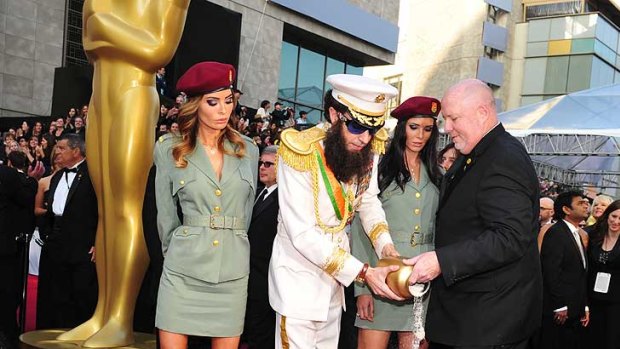 Carpeted ... Sacha Baron Cohen scatters "Kim Jong Il's ashes" on the red carpet at the Academy Awards.