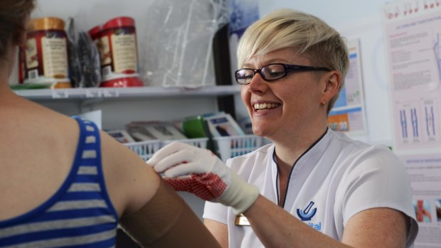 Extra care: ACT Telstra Business Woman of the Year, Samantha Kourtis, measures a patient for a
pressure bandage.
