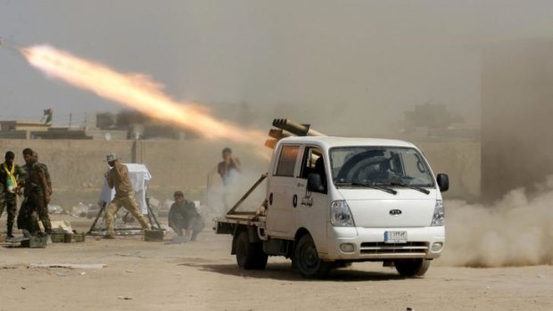 Iraqi security forces and Shiite militiamen fire at Islamic State positions north of Baghdad. 