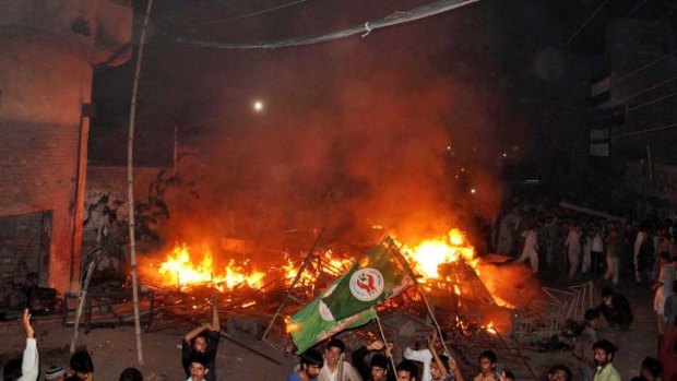 An angry mob after they set fire to household items belonging to a minority Ahmadi Muslim resident in the low-income Arafat Colony in Gujranwala, some 112 kilometres north of Lahore. 