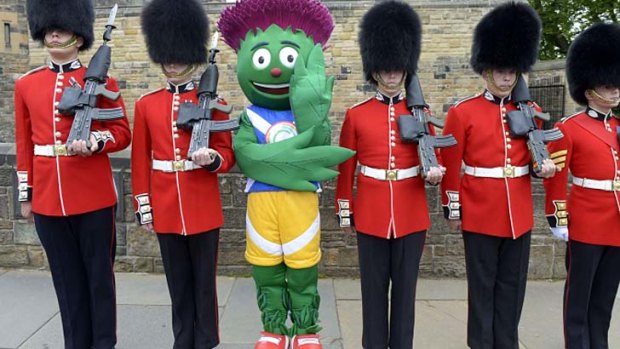 Making an appearance: Glasgow 2014 mascot Clyde lines up with the Scots Guards.