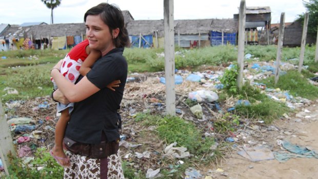 Future Cambodia Fund director Kylie Tattersall in Andong, a settlement outside Phnom Penh. She holds a girl whose father was shot dead over a $US2.50 debt.