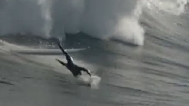 Another surfer is sent flying from his board as he tackles a huge wave
