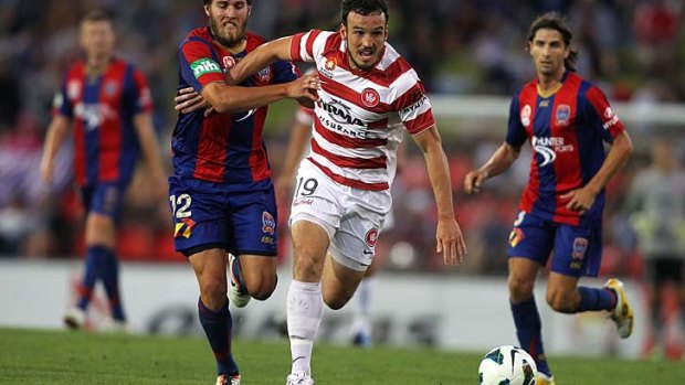 Mark Bridge of the Wanderers is challenged by Joshua Brillante of the Jets.