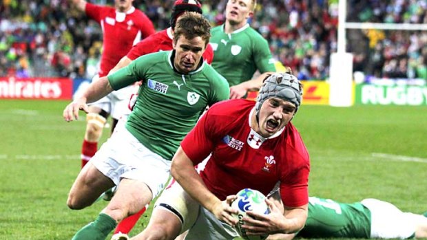 Sloppy defence ... Jonathan Davies scores a try for Wales after beating four Ireland players.
