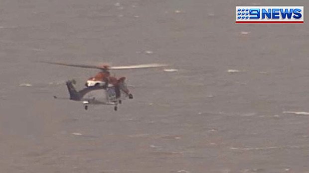 A helicopter crew searches for a man believed missing in the Port of Brisbane.