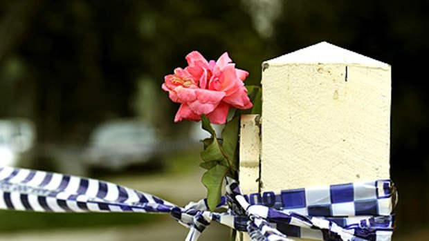 A flower on the front fence of the Heidelberg Heights house in which four people died.