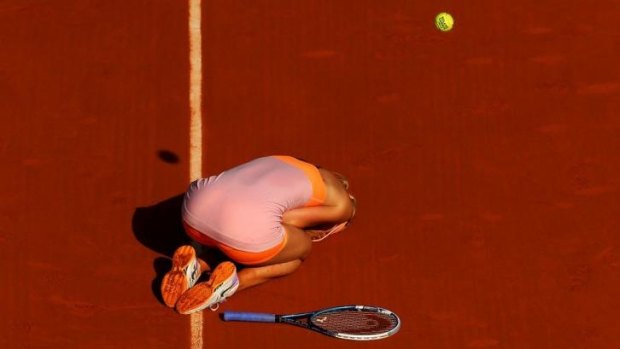 The moment of victory: Maria Sharapova slumps to her knees after a three-hour epic against Simona Halep.