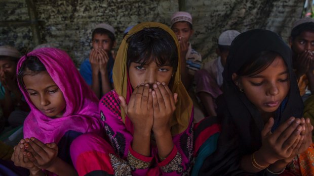 Rohingya Muslim girls, who crossed over from Myanmar into Bangladesh, pray at the end of their Quranic lesson in a newly opened madrasa, or religious school, at Kutupalong refugee camp, Bangladesh on Sunday.
