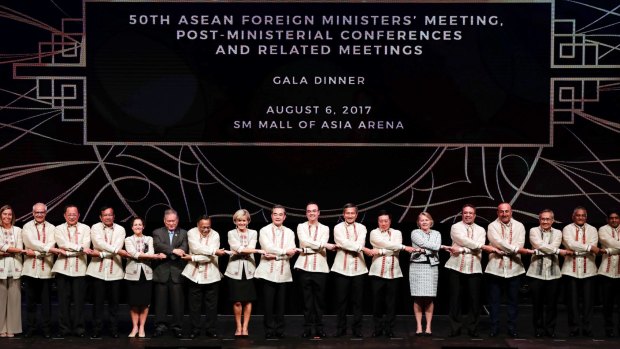 Foreign ministers from Southeast Asia and their dialogue partners link arms during the gala dinner of ASEAN foreign ministers' meeting  in the  Philippines on Sunday.