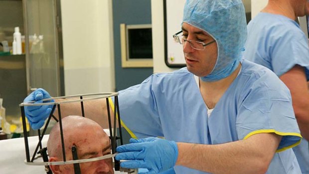 Associate Professor Richard Bittar prepares a patient for deep brain stimulation surgery.