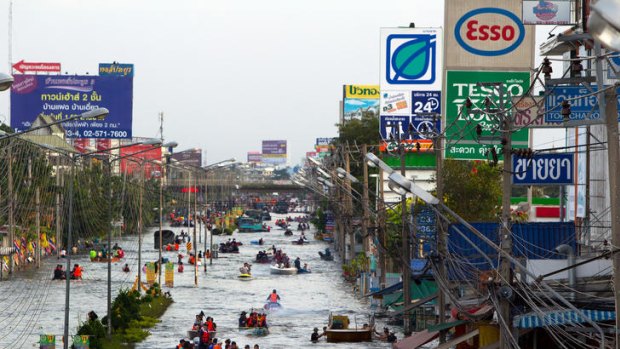 Residents take to boats on the flooded streets of Bangbuathong, on the outskirts of Bangkok.