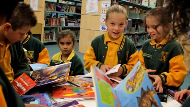 New page... Hebersham Public School students (from left) Jayden Rapley, Kathleen Kennedy, Alexcia Fullwood and Jesika Grenfell pore over books.