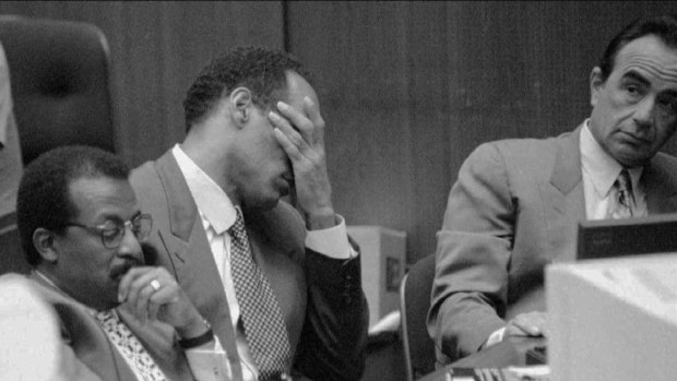 O.J.  Simpson holds his head as the defence counsel, including Johnnie Cochran jnr, left, and Robert Shapiro listen to the prosecution rebut opening statements. 