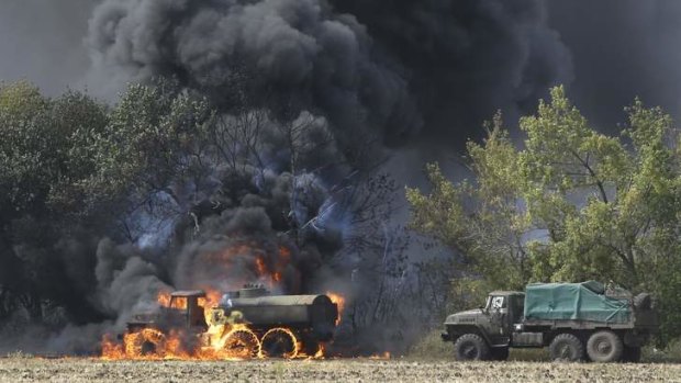 The fighting goes on: Vehicles burn on a country road in eastern Ukraine.