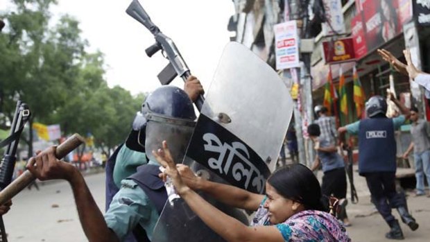 A Bangladeshi garment worker clashes with a police officer during demonstrations for a wage rise.