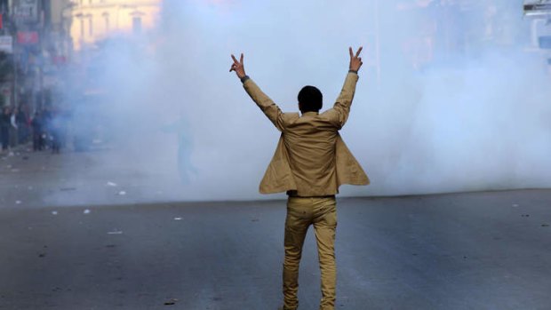 A supporter of the Egyptian government flashes the sign for victory during clashes with Muslim Brotherhood supporters in Cairo.