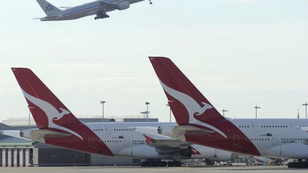Two Qantas A380 aircraft parked at the terminal at London Heathrow.