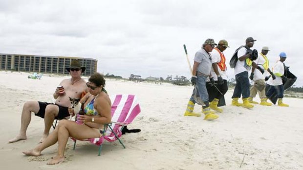 Oil patrol ... Johnny and Lisa Dean make the most of a day at the beach as a  crew looks for any oil that washed  up on Dolphin Island, Alabama.
