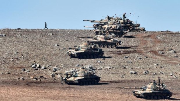 Turkish tanks line up on a hill outside the village of Mursitpinar next to the Syrian town Kobane.