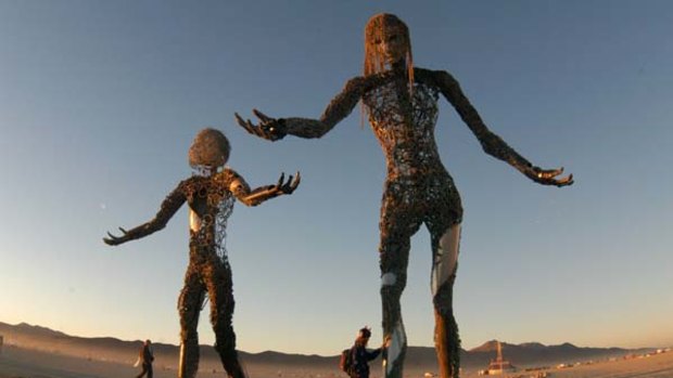 Visitors look at giant steel sculptures during the Burning Man festival in the Black Rock Desert.