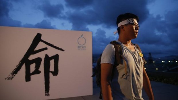 A protester stands beside a sign that translates as "disobedience" during a rally organised by Occupy Central with Love and Peace. 