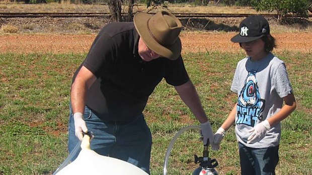 Robert and his son pump the weather balloon with helium before launch.