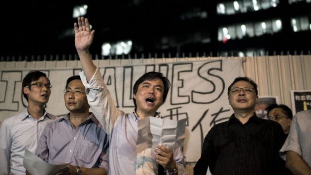 Edward Chin (centre), organiser of Financial Professionals for Occupy Central, and Benny Tai (right), co-founder of the Occupy Central movement, chant slogans at a protest outside government offices in Hong Kong on Friday. 