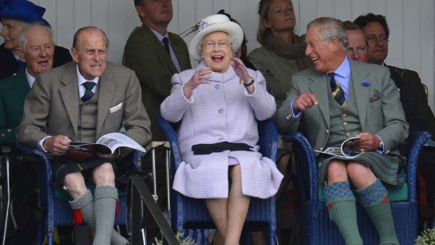 Highland tradition: At least the Queen and Prince Charles are amused by the weekend Braemar Gathering's sack race in chilly Scotland.
