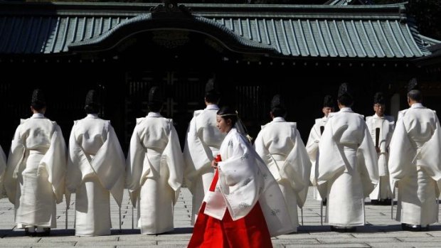 Controversial: A shrine maiden walks behind Shinto priests before a ritual to cleanse themselves at the Yasukuni Shrine during the Annual Autumn Festival in Tokyo on October 17.
