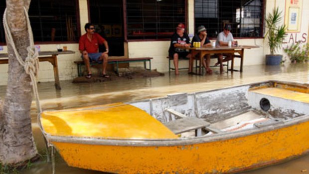 Drinking dry ... drinkers enjoy a beer at the Pioneer Hotel in Rockhampton as the floodwaters reached their peak.