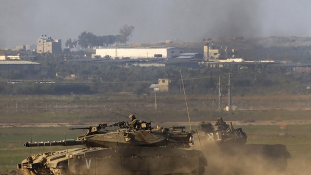 Israeli tanks manoeuvre near the Gaza Strip  before crossing into the Palestinian-controlled territory.