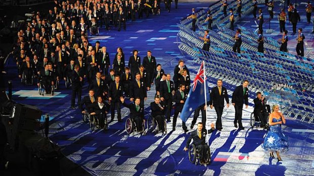 Passion and pride: Wheelchair rugby player Greg Smith carries the flag for the Australian team during the opening ceremony of the London Paralympic Games.