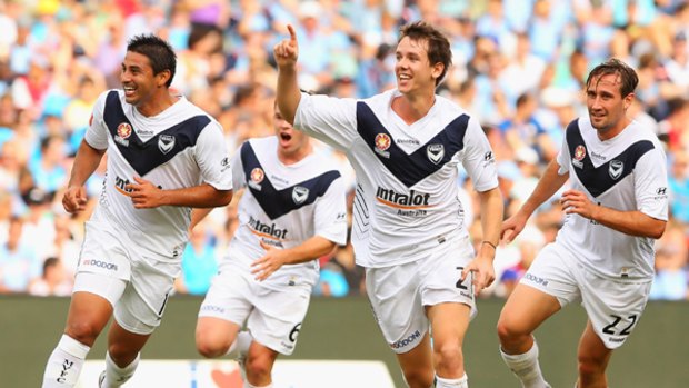 Melbourne's Robbie Kruse celebrates with teammates after scoring the first goal for Victory against Sydney yesterday.
