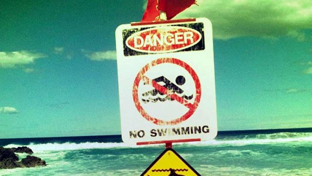 Signs warn beachgoers to stay out of the water on North Stradbroke Island.