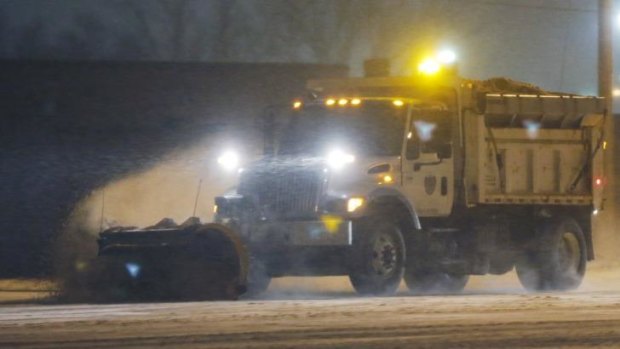 A city snow plow clears drifts of snow along US 59 in Lawrence, Kansas.