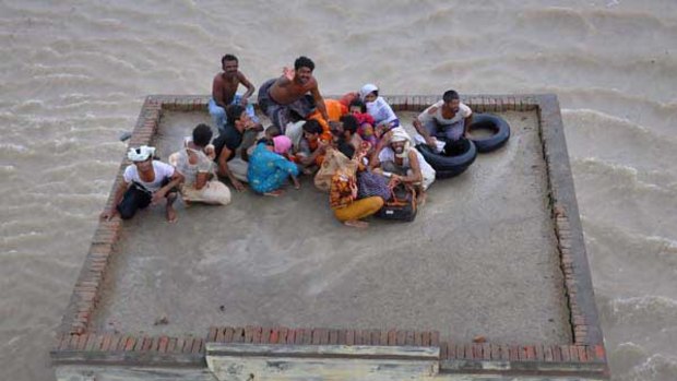 A family takes refuge on a mosque, awaiting rescue from floodwaters in the south of Punjab. Parts of the province have been described as a giant lake. <i>Picture: Reuters</i>