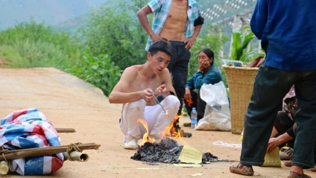 Xiao Gongchao burns paper offerings for his dead grandmother and nephew. 