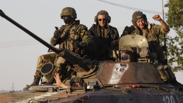 Ukrainian servicemen ride on an armoured vehicle in Mariupol following the ceasfire.